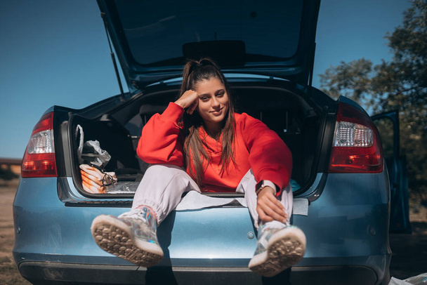 Attractive young woman resting in the trunk of a car - Φωτογραφία, εικόνα