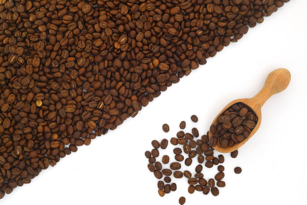 Kaffeebohnen in einer Holzschaufel isoliert auf weißem Hintergrund. Geröstete Kaffeebohnen isoliert. Eine hölzerne Schaufel mit Kaffee. - Foto, Bild