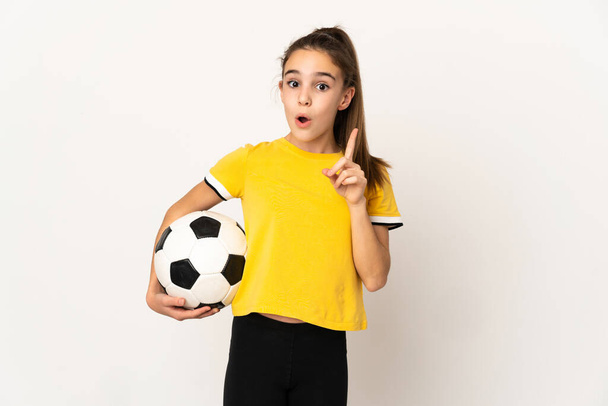 小さなサッカー選手の女の子は指を持ち上げながら解決策を実現しようとして白い背景に隔離されます - 写真・画像