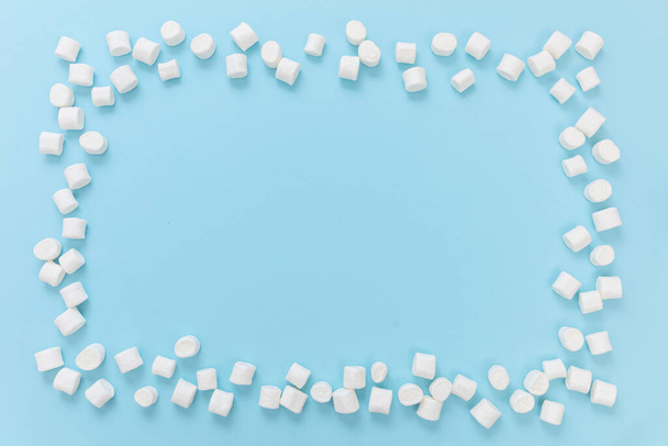 Marshmallow-Rahmen auf pastellblauem Hintergrund, Kopierraum. Weiße flauschige Mini-Dessert, Kinder Geburtstagsparty Einladung Vorlage. - Foto, Bild