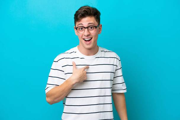 Young handsome Brazilian man isolated on blue background with surprise facial expression - Zdjęcie, obraz