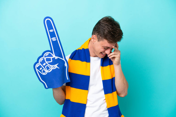 Young sports fan man isolated on blue background laughing - Photo, Image