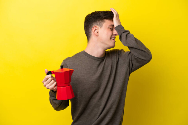 Young Brazilian man holding coffee pot isolated on yellow background has realized something and intending the solution - Фото, зображення