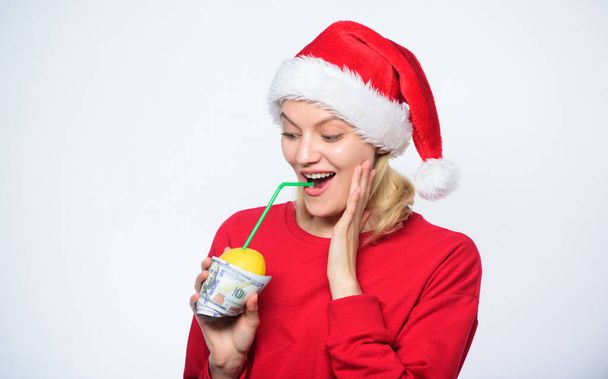 Girl with lemon and money. Lemon money concept. Girl santa hat drink juice lemon wrapped in banknote. Totally natural lemon juice. Fresh lemonade drink with straw. Symbol of wealth and richness - Фото, изображение