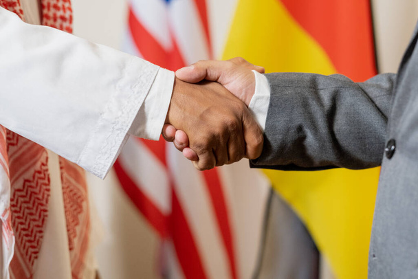 A politikai partnerek vagy a külföldi küldöttek zászlókkal szembeni kézfogása - Fotó, kép