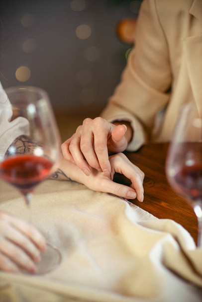 lesbian couple having dinner in a restaurant Close-up of hands of a loving couple - Photo, image