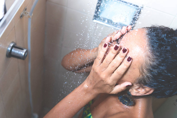 バスルームで自分自身を洗う女性の肖像画。サルバドール,バイーア,ブラジル. - 写真・画像