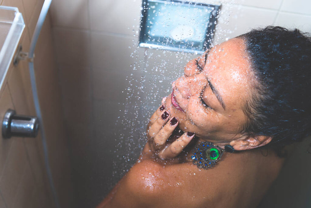 バスルームで自分自身を洗う女性の肖像画。サルバドール,バイーア,ブラジル. - 写真・画像