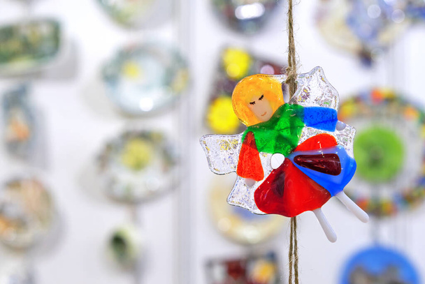 Glass figurine of an angel in colorful clothes. - Foto, Bild
