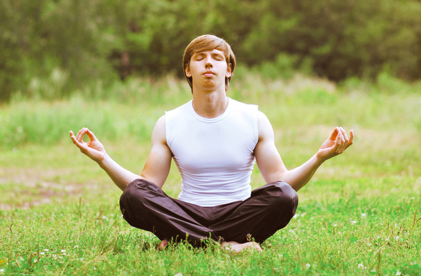 Yoga man relaxation outdoors on the grass - Photo, Image