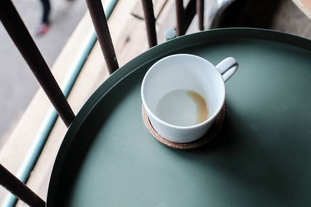Vacía la taza de café después de beber sobre fondo de mesa verde por la mañana. Vajilla para café y té, chocolate, espresso. - Foto, imagen