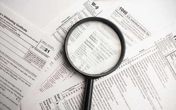 Tax Form 1040 with magnifying glass. Tax concept - Foto, Imagen