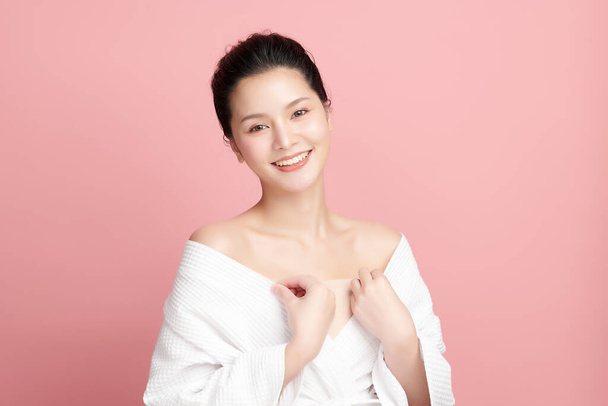 Schöne junge asiatische Frau mit sauberer, frischer Haut auf rosa Hintergrund, Gesichtspflege, Gesichtsbehandlung, Kosmetologie, Schönheit und Wellness, asiatische Frauenporträt. - Foto, Bild