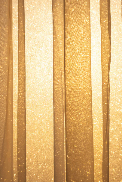 Rays of sun light shines through transparent curtain and frosty window from outdoor to room, close up. - Photo, Image