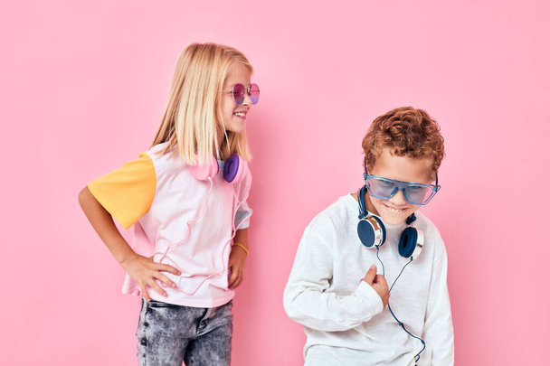 μοντέρνο αγόρι και κορίτσι φορώντας ακουστικά θέτουν Ακούγοντας μουσική - Φωτογραφία, εικόνα