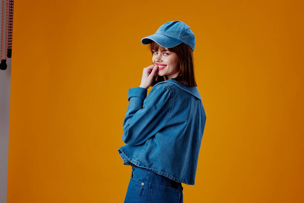 Краса Мода жінка в шапці і джинсовій куртці позує кольоровий фон незмінним
 - Фото, зображення