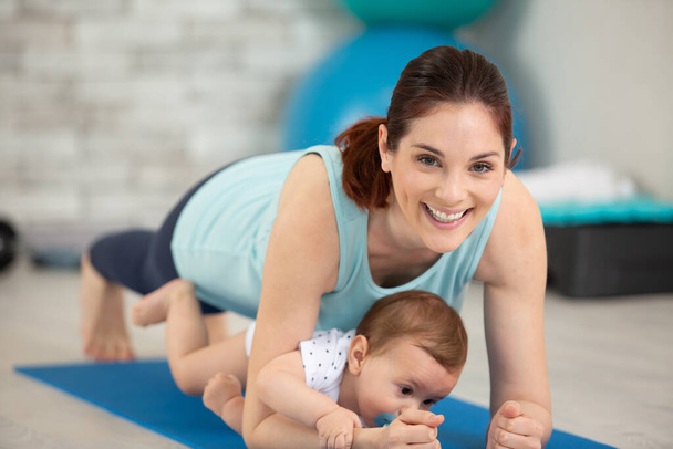 young mother does physical yoga exercises together with her baby - Valokuva, kuva
