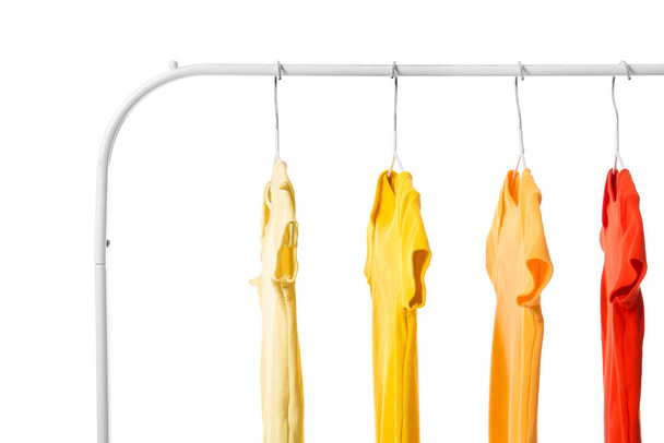 Rack with colorful baby bodysuits on white background - Foto, Bild