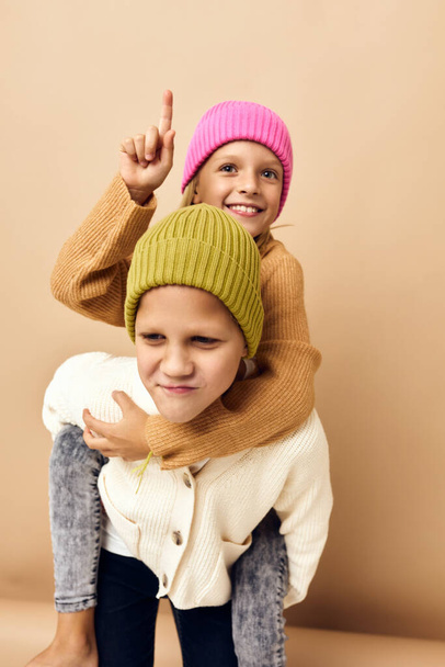 niño y niña juntos en sombreros multicolores divertido casual desgaste fondo beige - Foto, imagen