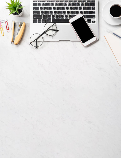 Stylized marble office working desk with smartphone, laptop, glasses and coffee, workspace design, mock up, topview, flatlay, copyspace, closeup - Foto, afbeelding