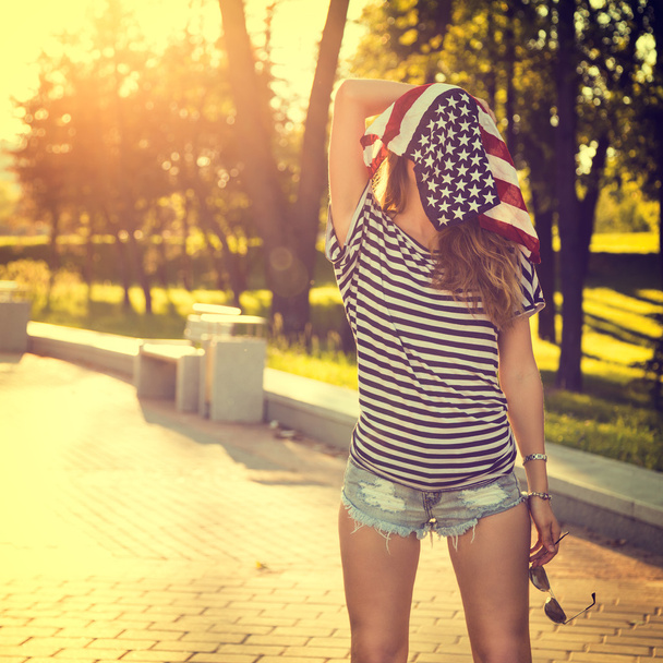 Divertente ragazza hipster con bandiera USA sulla sua testa
 - Foto, immagini
