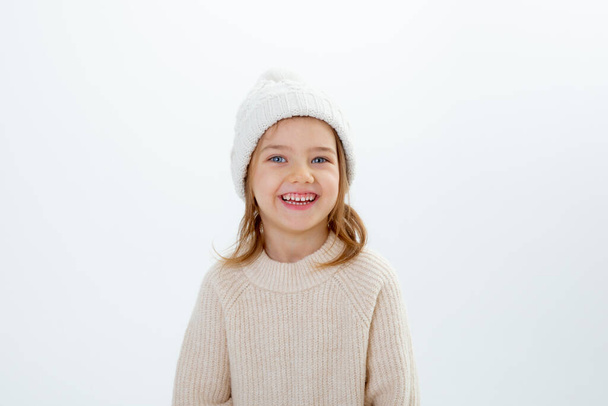 cute little kid in winter hat with boxes of gifts isolated on a white background - Valokuva, kuva