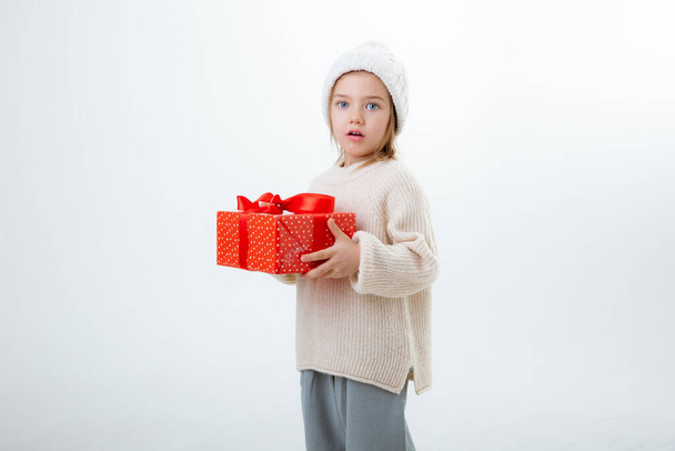 可愛い冬の帽子に白い背景に孤立した贈り物の箱 - 写真・画像