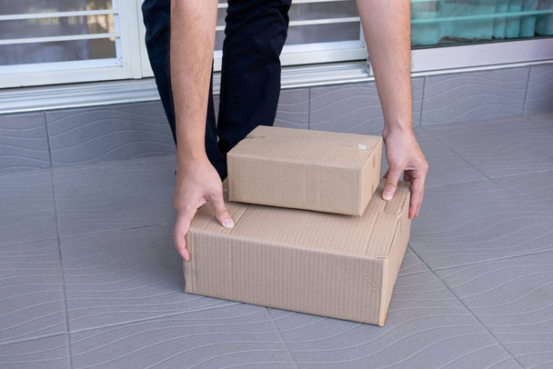 Koncept e-commerce muž opouští domov a zvedá krabice za to, že je posílá svým zákazníkům prostřednictvím sledovacího expresu. - Fotografie, Obrázek