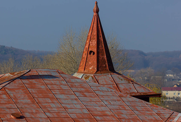 The roof of the house is made of red metal tiles, a beautiful large chimney. - Photo, Image