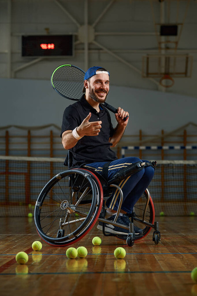 Nuori mies pyörätuolissa pelaa tennistä kentällä - Valokuva, kuva