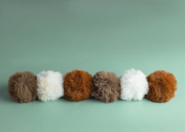Border made of fluffy Christmas balls made from faux fur in neutral colors. Alternative Christmas decoration without plastic. - Zdjęcie, obraz