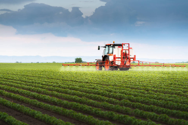 Tractor rociando pesticidas en campo de soja con pulverizador en primavera - Foto, imagen