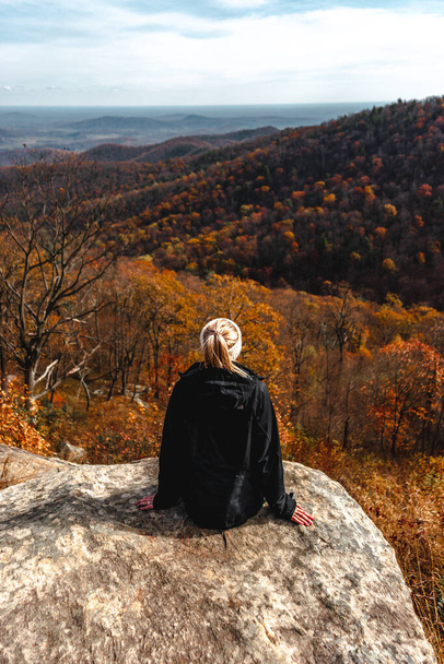 a young woman sitting on a rock   - Foto, Bild