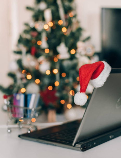 christmas tree with laptop and santa hat on table - Fotoğraf, Görsel