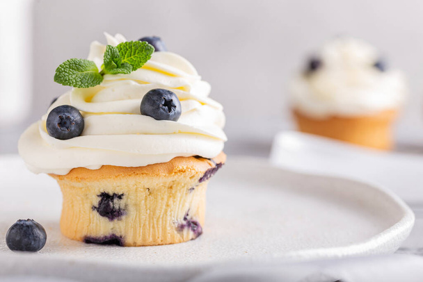 Sweet muffins with blueberries and cheese cream - Fotó, kép