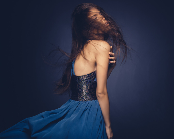 Attractive girl with flying hair posing in studio - Foto, Bild
