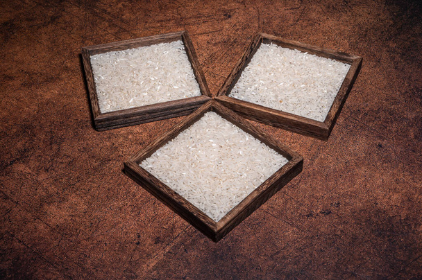 Some square containers of white rice in the dark background - Foto, immagini