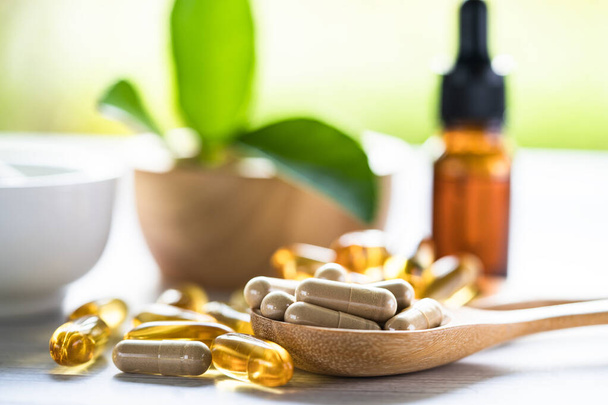 Alternatív gyógyászat gyógynövény szerves kapszula E-vitamin omega 3 halolaj, ásványi anyag, gyógyszer gyógynövények levél természetes kiegészítők az egészséges jó élet. - Fotó, kép