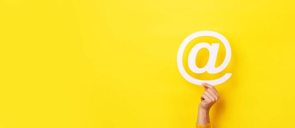 электронная почта знак в руке на желтом фоне, панорамный макет - Фото, изображение
