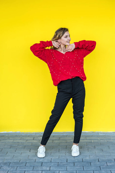 divat nő klasszikus piros kötött pulóver pózol és mosolyog a sárga háttér. életmód - Fotó, kép