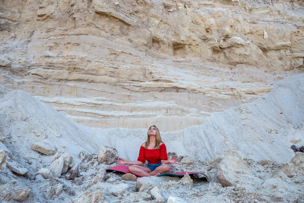 mladá hezká štíhlá žena dělá cvičení relaxovat jóga cvičení v přírodním písku lomu. zdravý životní styl - Fotografie, Obrázek