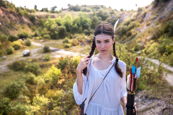 Молода жінка в стилі корінних народів Америки з луком і стрілою в природі - Фото, зображення