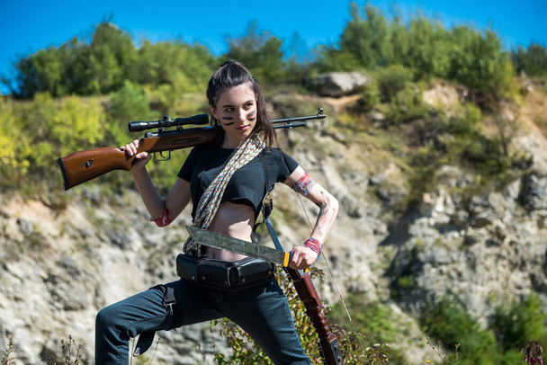 Sexy cazador con rifle posando al aire libre, hora de verano - Foto, Imagen