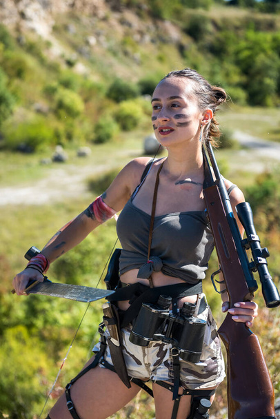junge Jägerin in der Spitze mit dem Gewehr, im Sommer in der Natur. Schütze - Foto, Bild