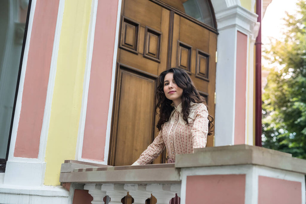  都会の通りのモダンな色の建物の近くのスタイリッシュな布の若いウクライナ人女性 - 写真・画像
