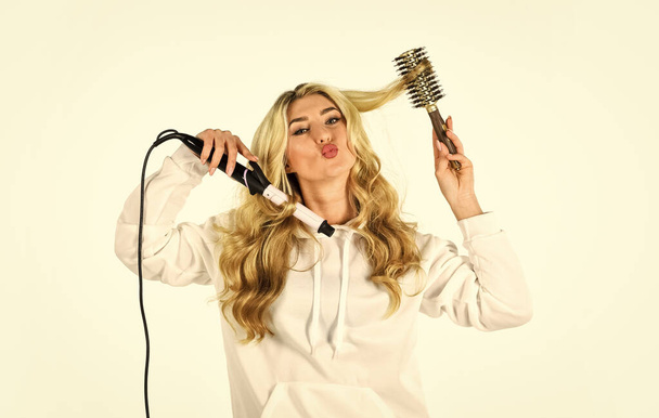 eco friendly salon. sexy woman has long curly blond hair. girl at hairdresser. Woman With Long Blonde Wavy Hair Ironing It. New hairstyle for today. fashion of beautiful lady. woman curling hair - Photo, Image