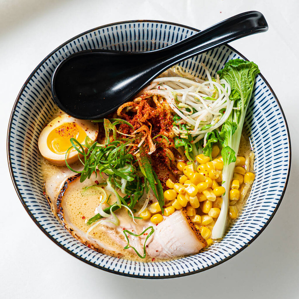 Asian noodles soup, ramen with chicken, tofu, vegetables and egg, close-up.  - Фото, изображение