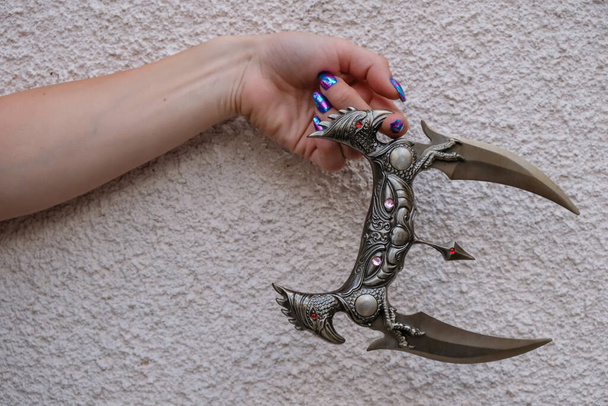 Kampfmesser mit dekorativem Griff im Ninja-Stil in der Hand der Frau. - Foto, Bild