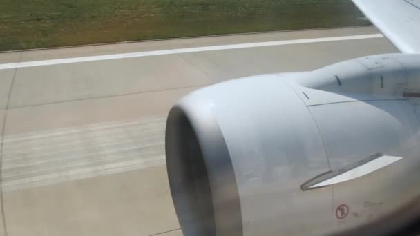 Pohled z okna letadla pohybujícího se na letišti. Připravuji se na odlet. Pohled na turbínu letadla a vypnutou dráhu. Vzletový moment letadla za letu, pohled z okna letadla, - Záběry, video