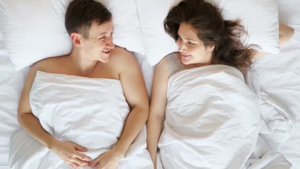 Mladý pár komunikuje po probuzení ležící v posteli - Záběry, video